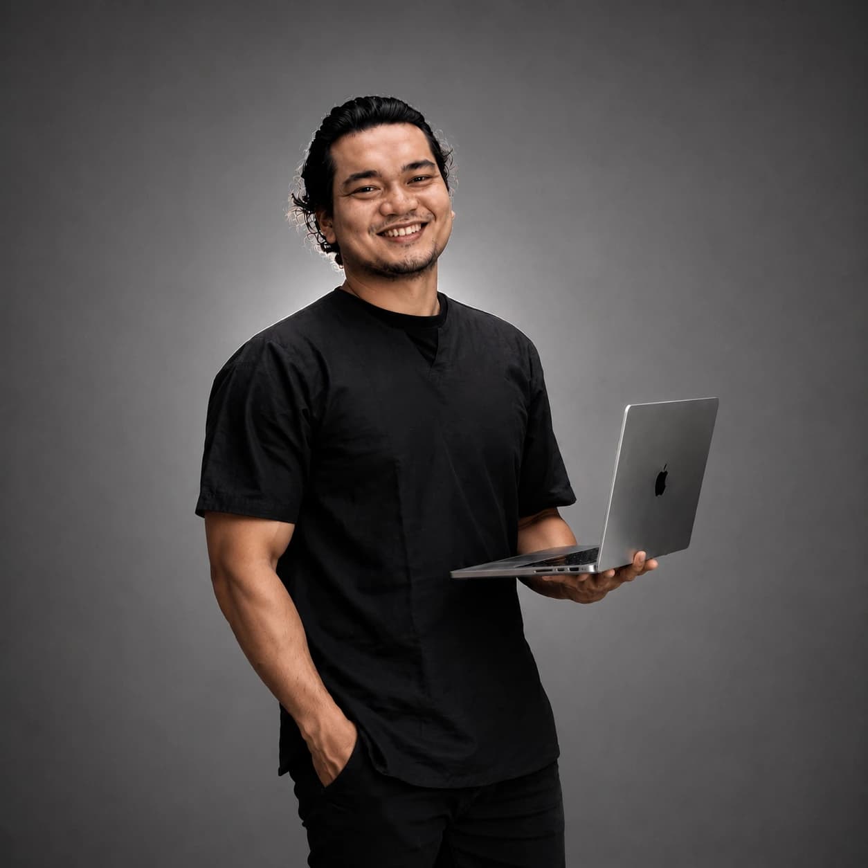 Angga Pratama holding a laptop